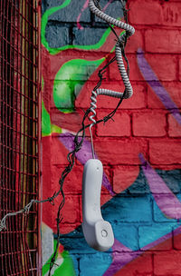 Close-up of illuminated lantern hanging against brick wall