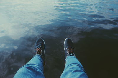 Low section of man standing by lake