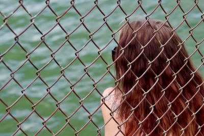 Rear view of chainlink fence against sky