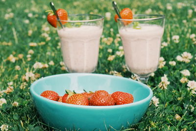 Close-up of strawberries in bowl with drinks
