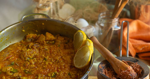 Seafood paella with lemon on kitchen table