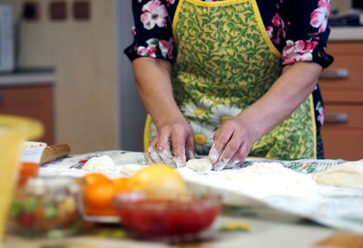 Woman in the kitchen kneads dough, close up photo. healthy homemade food concept.