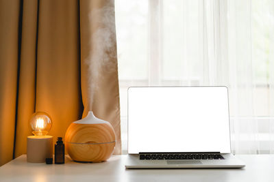 Aroma oil diffuser in work place, laptop and home decor