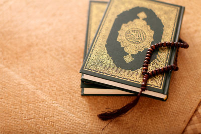 Close-up of bead necklace on koran at table