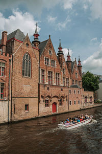 Boat and old brick buildings on canal at bruges. a town full of canals and old buildings in belgium.