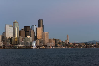 City at waterfront against clear sky