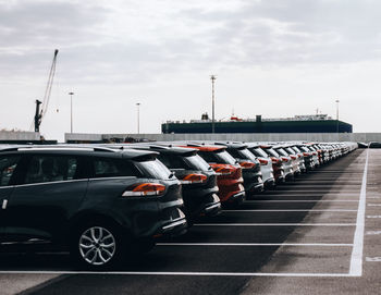 Vehicles on road against sky in city