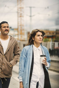 Male and female passengers walking at tram station