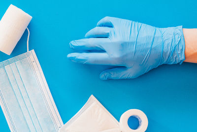 Close-up of hand on table against blue background