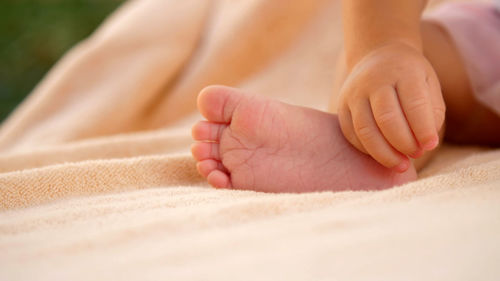 Soft focus, a close-up of tiny, little baby feet on light coverlet background