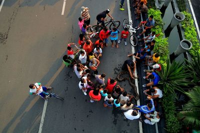 Snake charmer amidst people sitting on street