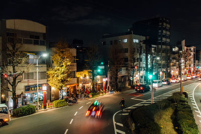 Blurred motion of car on illuminated street at night