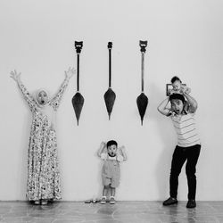 Full length of children standing against wall