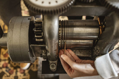 Cropped hand of man repairing machine