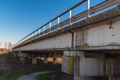 Side view of a long road viaduct built in reinforced concrete with guard rail.