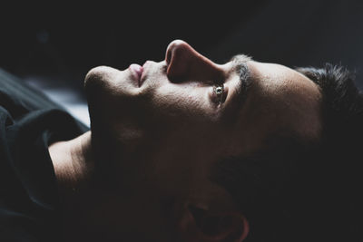 Close-up portrait of young man against black background