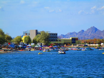 Boats in city against blue sky