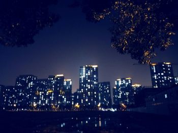 Illuminated cityscape against sky at night