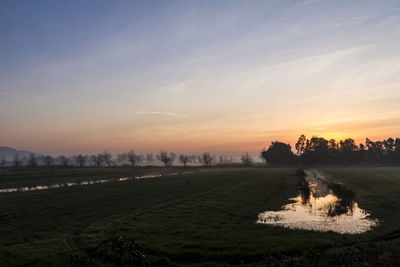 Scenic view of field against sky during sunset