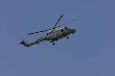 Low angle view of helicopter in clear blue sky