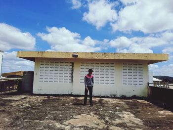 Full length of man standing by building against sky