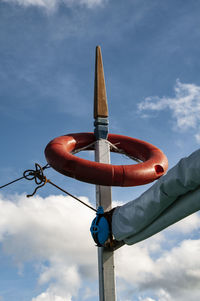 Low angle view of life belt on pole against sky