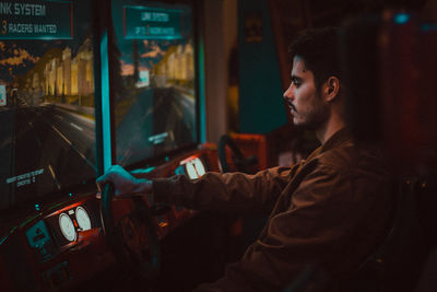 Side view of young man using smart phone at home