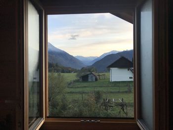 Scenic view of mountains against sky seen through window