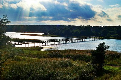 Scenic view of river against cloudy sky