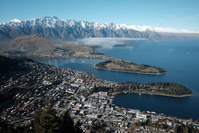 Aerial view of city by sea against sky