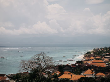 High angle view of townscape by sea against sky