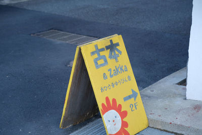 High angle view of yellow sign on road in city