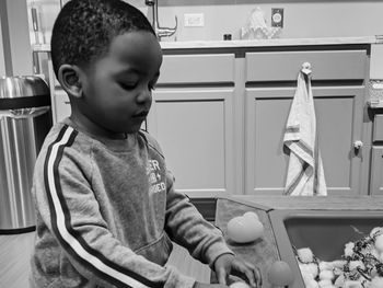 Side view of boy playing with toys at home