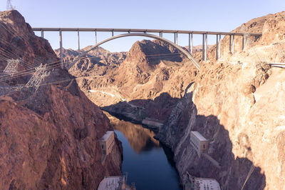 Arch bridge over river against sky