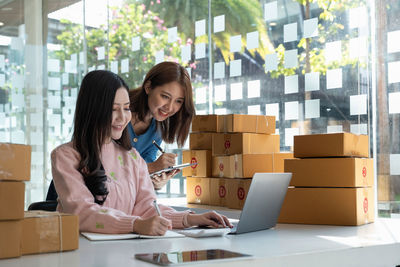 Smiling businesswoman with colleague working at desk