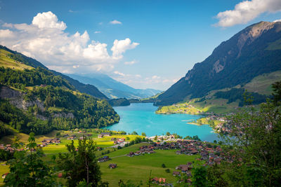 Scenic view of lake and mountains against sky in town