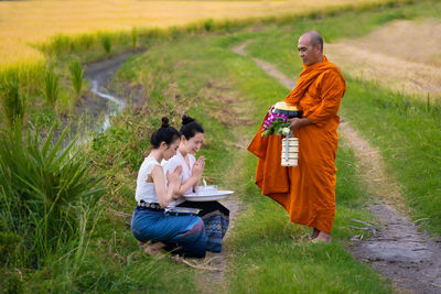 Rear view of couple sitting on field