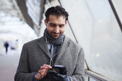 Businessman using phone outdoors in city