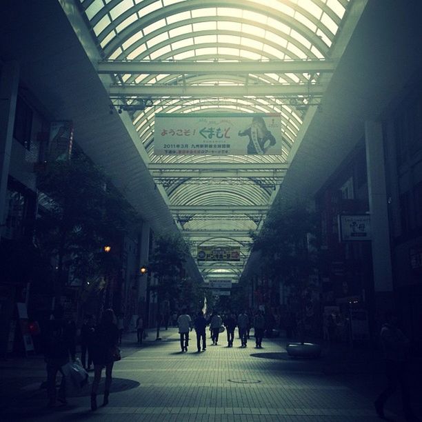 indoors, architecture, ceiling, large group of people, built structure, men, person, shopping mall, illuminated, city life, walking, lifestyles, travel, incidental people, the way forward, modern, travel destinations, railroad station, diminishing perspective