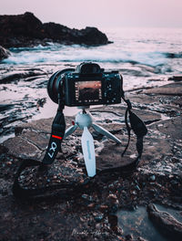 Vintage camera on beach against sea