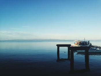 Pier over sea against blue sky