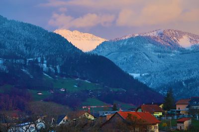 Scenic view of townscape by mountains against sky