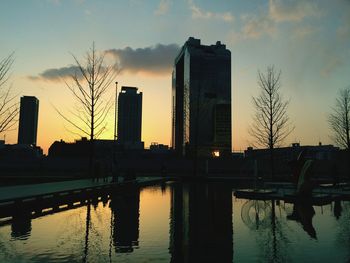 Reflection of buildings in river at sunset