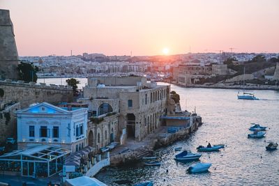 Boats in river at sunset