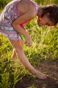 Side view of woman sitting on grassy field