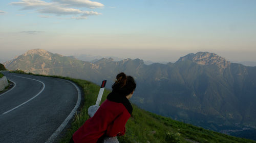 Rear view of woman looking at mountain range against sky