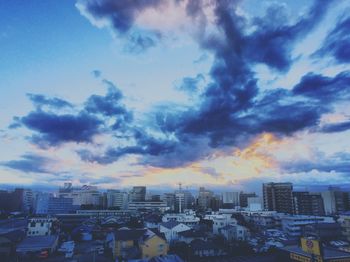 Buildings against cloudy sky at sunset