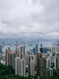 Aerial view of cityscape against cloudy sky