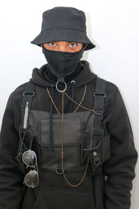 Portrait of man wearing hat standing against white background