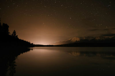 Scenic view of lake against sky at night